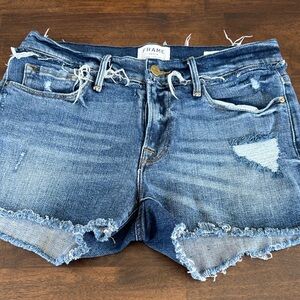 Frame Le Cutoff denim shorts feature distressing and a medium wash.